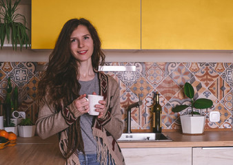 blurred  beautiful smiling healthy young woman holding cup and smiling in the kitchen