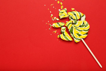 Broken lollipop candy on red background