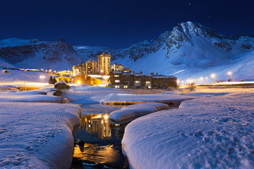 Ski resort at night. French Ski resort Tignes, beneath towering mountains, night time Blue Hour. ...