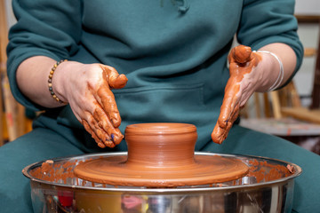 modeling work on pottery wheel hands close-up view straight