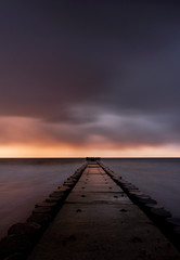 Obraz na płótnie Canvas Molo na wybrzeżu Morza Bałtyckiego o zachodzie słońca,Kołobrzeg,Polska.