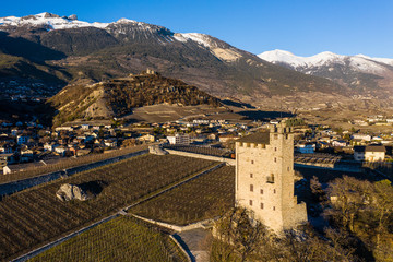 Medieval tower and a vineyard castle on the top of hill near the town of Sierre in Valais, Switzerland