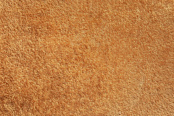 Brown natural cotton terry cloth for a beach towel. Texture of fluffy soft and delicate colors of cocoa background, textured fabric close up macro.