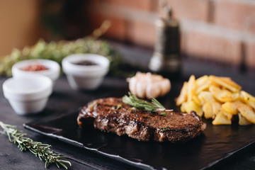 Rare filet mignon beefsteak with roasted potatoes, above view