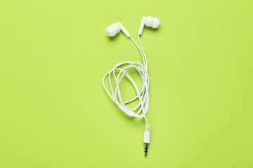 White earphones on green background