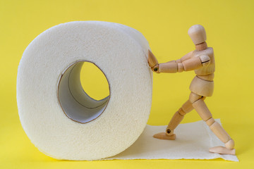 Wooden man pushes a roll of toilet paper