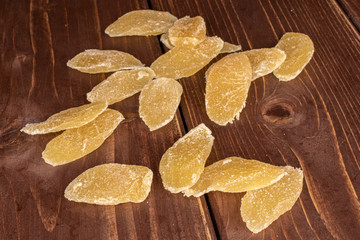 Lot of slices of dried yellow pineapple on brown wood