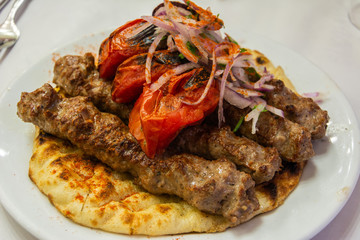 Greek souvlaki kebap with grilled tomatoes, on a pita bread.