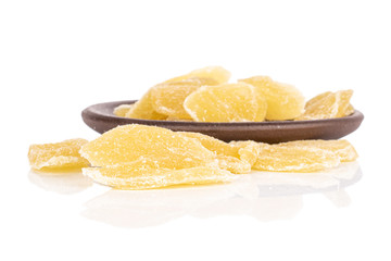 Lot of slices of sweet dried yellow pineapple with brown ceramic coaster isolated on white background