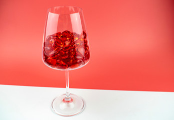 Glasses filled with crystal hearts on a red and white background.