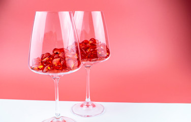 Glasses filled with crystal hearts on a red and white background.