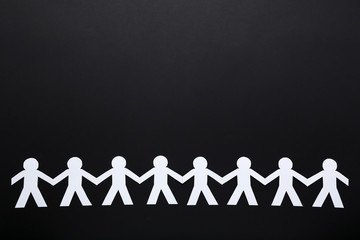 Paper chain people on black background