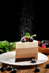 Piece of light mousse cake with fruits on on wooden surface. Mousse cake recipe for three...