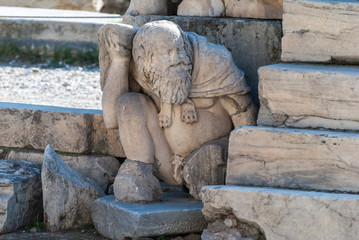 Ancient statue among the ruins of Acropolis of Athens in Greece.