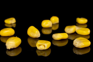Lot of pieces of canned yellow corn sweet isolated on black glass