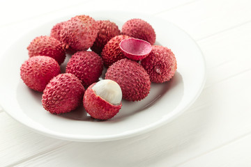 Tasty lychee in plate on white wooden table