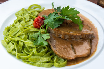 Roasted minced meat on rosemary creamsauce with spinach noodles