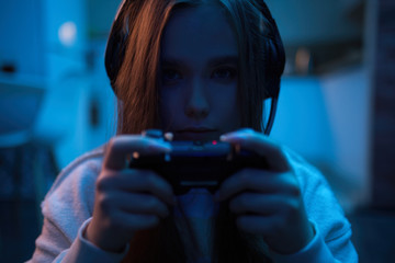 girl in headphones, plays video games at night.