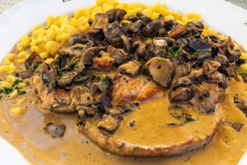 Geschnetzeltes farmer style dish of chopped pork, cooked in sauce, with mushrooms and spatzle.