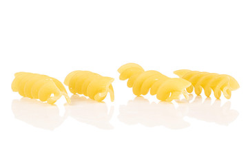 Group of four whole yellow pasta fusilli isolated on white background