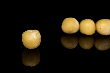 Group of four whole canned pea isolated on black glass