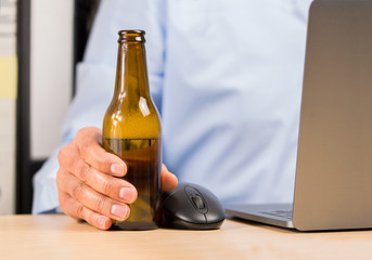 and of a businessman in the office drinking a bottle of beer