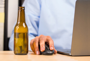 hand of a businessman in the office drinking a bottle of beer