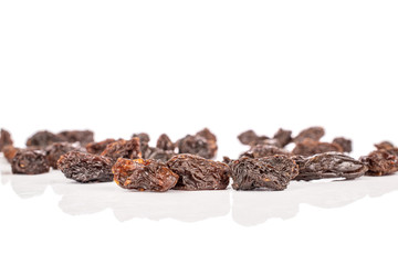 Lot of whole dried dark raisin front focus isolated on white background