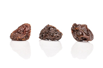 Group of three whole dried dark raisin isolated on white background