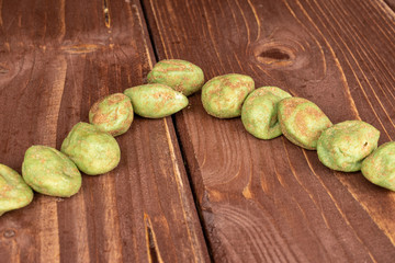 Lot of whole wasabi green peanut on brown wood