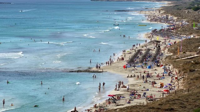 Aerial view of the "Son Bou" Beach, Balearic Islands.Time Lapse Panoramic with many people walking and the movement of waves, on the longest beach on the island of Menorca (municipality of Alaior), Sp