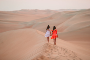 Girls among dunes in Rub al-Khali desert in United Arab Emirates