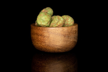 Lot of whole wasabi green peanut in bamboo bowl isolated on black glass