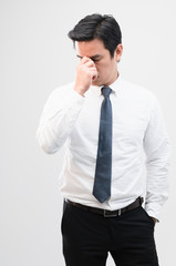 Exhausted Asian worker Squeezing between the eyebrows to try relaxing from hard work shows pain expression face, concept working exhausted, office worker lifestyle, office syndrome, tiring work hour.