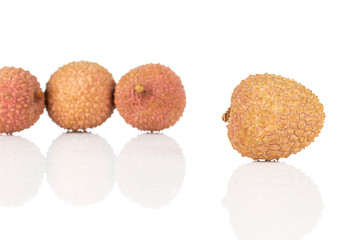 Group of four whole fresh lychee fruit isolated on white background