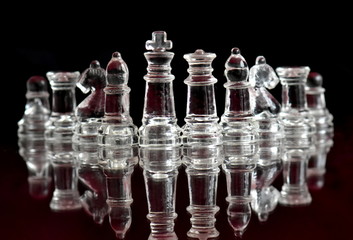 glass chess figures on black background