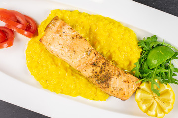 Beautiful grilled salmon with potato mash on white rectangular ceramic plate flatlay on grey stone