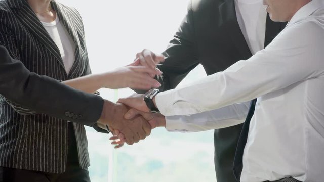 Group of business people pile of hand for startup project together with partner in the office, business man and woman happy putting hand for unity and teamwork for success in work collaboration.