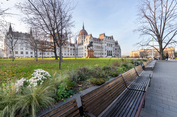 Hungarian parliament building and park from behind on a sunny day in autumn season from an angled view.