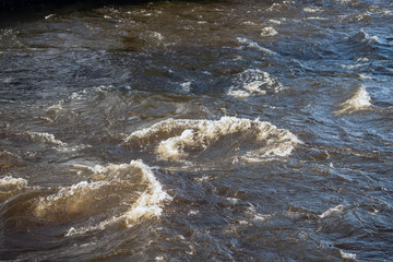 Quick water flow in a river, Nature background. Selective focus.