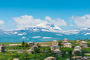 Armenian mountain with a snowy peak and a view of the Armenian village