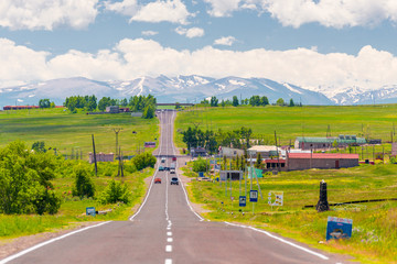 Fototapeta na wymiar motorway through the village of Armenia overlooking the mountains with snowy peaks