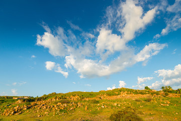mountains of Armenia, covered with greenery and  stones, clouds on a blue sky on a sunny day
