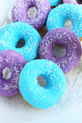 pink and blue doughnuts next to a glass of milk