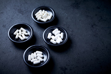 Lysine, Proline, Arginine (Cardio Amino Acids) and Magnesium. Support for Heart Health. Dietary Supplements  on dark stone background. Copy space