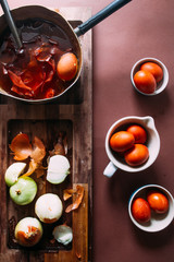Dyeing eggs for Easter holidays, coloring with different color and tonality using natural food dye pigment and painting color, over a white  background, chocolate eggs , top view, flatlay,soft light