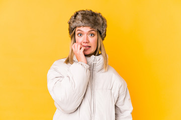 Young blonde woman wearing a winter clothes isolated Young blonde woman isolated on yellow background biting fingernails, nervous and very anxious.< mixto >