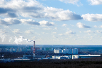 Obraz premium City with big houses behind the forest, factory chimney with smoke