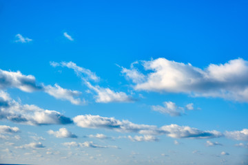 Cloudy sky in clear weather, copy space background. Cumulus cloud on a sunny winter day. White clouds against a blue sky.
