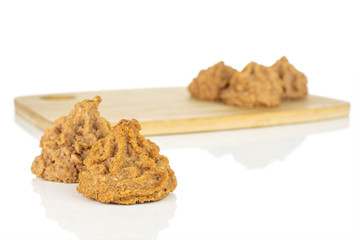 Group of five whole homemade brown coconut biscuit with chocolate on bamboo cutting board isolated on white background